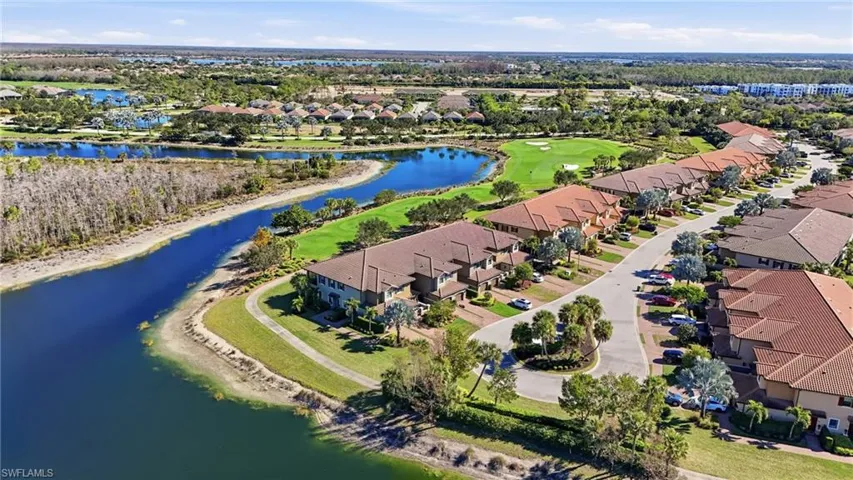 Aerial perspective of suburban area featuring a large body of water and a golf course