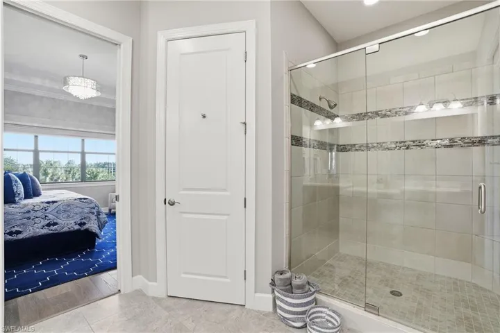 Ensuite bathroom with a shower stall and baseboards