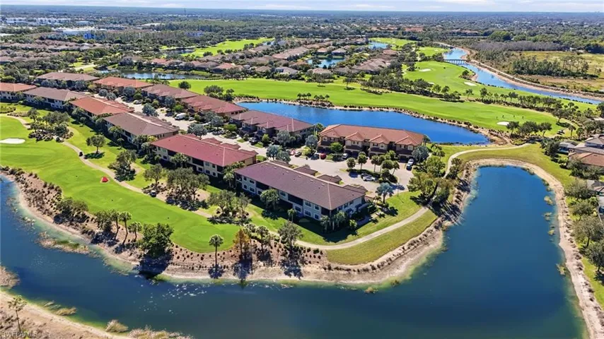 Aerial perspective of suburban area featuring a golf club and a nearby body of water