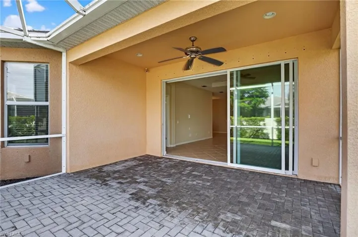 View of patio with a ceiling fan and a sunroom