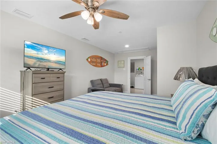 Bedroom featuring attic access, a ceiling fan, and washer / clothes dryer