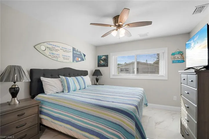 Bedroom with light marble finish floors and ceiling fan