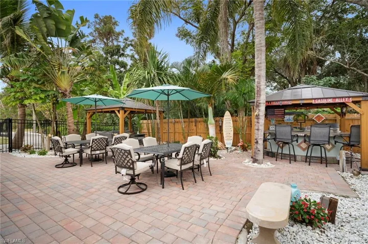 Fenced backyard featuring a gazebo, outdoor dining area, and a patio area