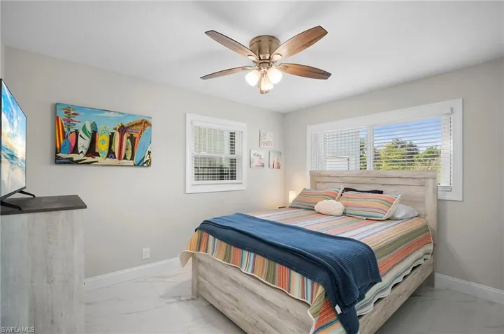 Bedroom with light marble finish floors and a ceiling fan