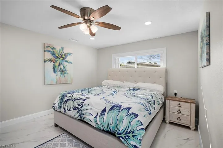 Bedroom featuring light marble finish flooring, a ceiling fan, and recessed lighting