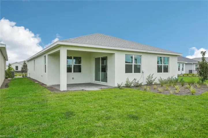 Rear view of house featuring a lawn and a patio