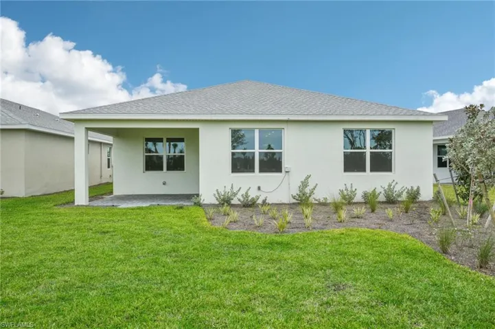 Back of house with a lawn