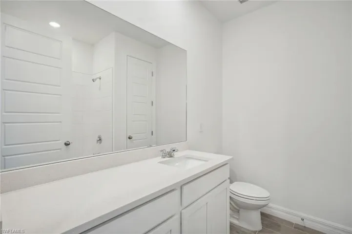 Bathroom with a shower, vanity, toilet, and hardwood / wood-style flooring