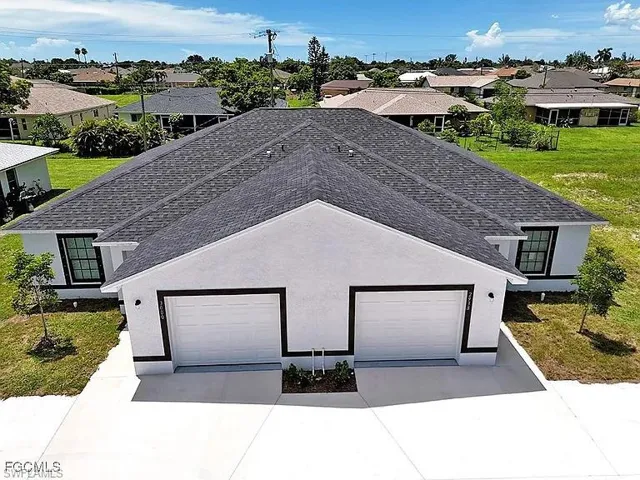 Contemporary stucco exterior with a dark asphalt shingle roof