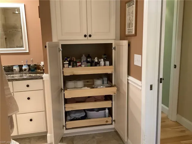 Master bath with large closet with pull-out drawers