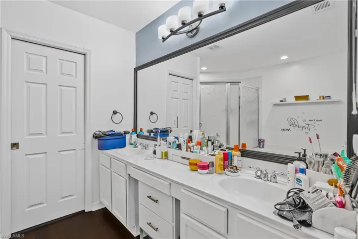 Bathroom with vanity, an enclosed shower, and hardwood / wood-style floors