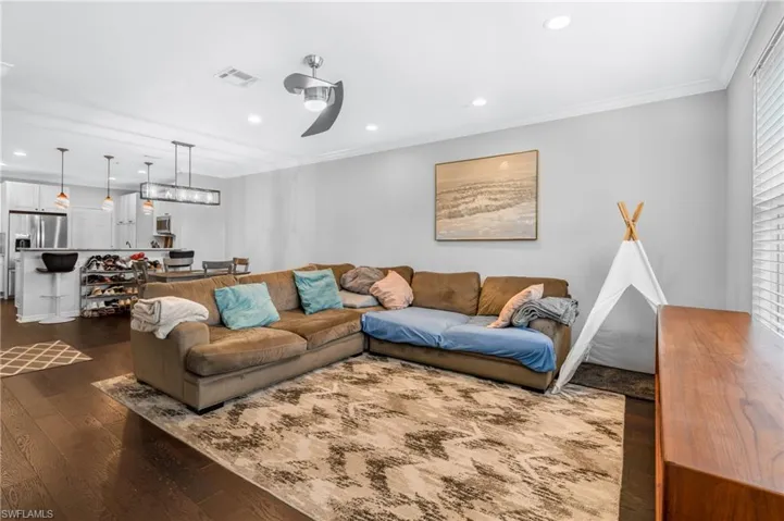 Living room with ornamental molding and dark hardwood / wood-style flooring