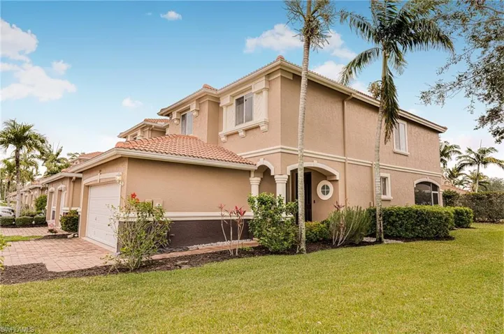 Mediterranean / spanish home featuring a garage and a front lawn