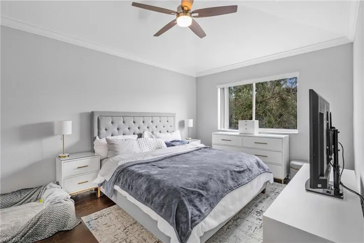 Bedroom featuring ornamental molding, dark hardwood / wood-style floors, and ceiling fan