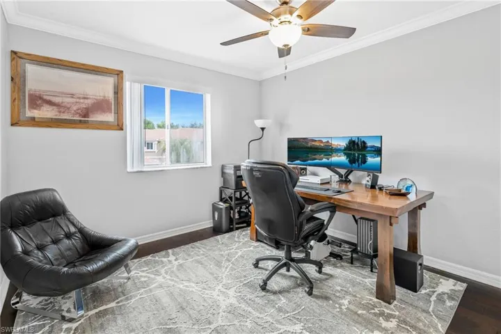 Office featuring ceiling fan, ornamental molding, and dark hardwood / wood-style flooring