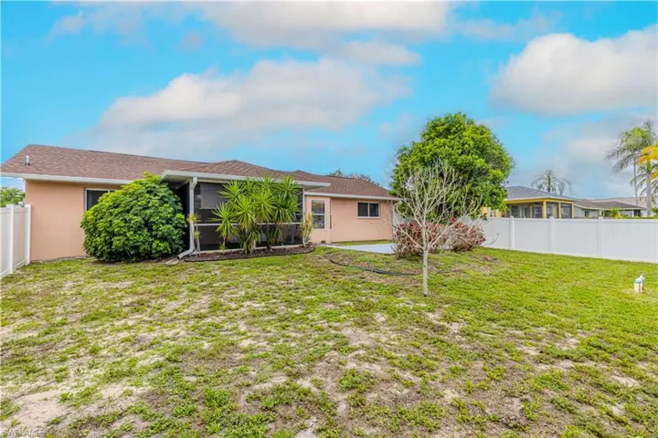 Rear view of property with a fenced backyard, stucco siding, and a sunroom