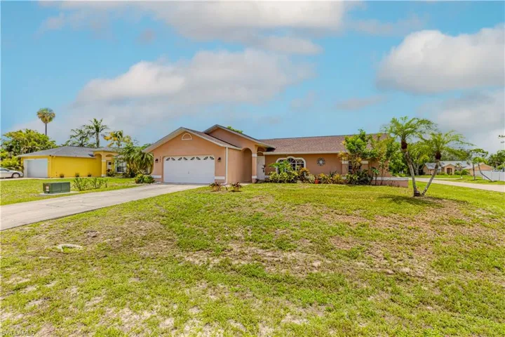 Single story home with driveway, a garage, stucco siding, and a front yard