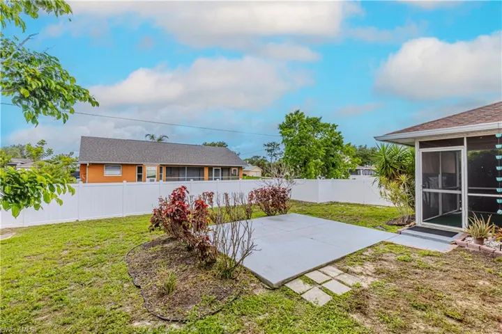 Fenced backyard featuring a sunroom and a patio area