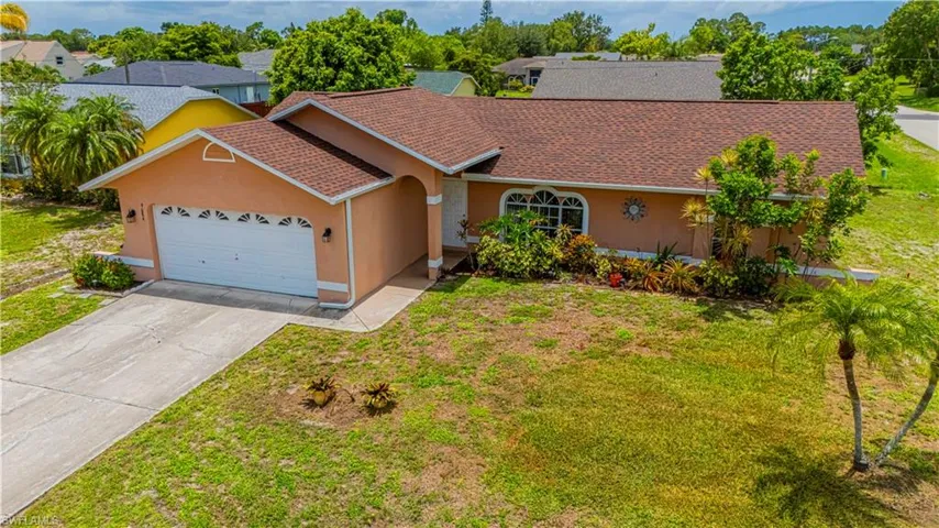 View of front of property with stucco siding, a garage, a front yard, and concrete driveway