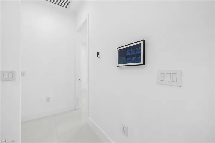 Corridor with baseboards and tile patterned floors