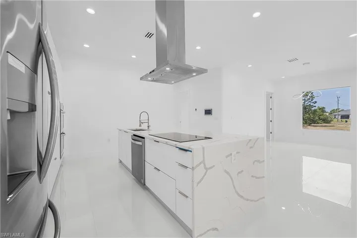 Kitchen featuring a sink, modern cabinets, stainless steel appliances, island range hood, and white cabinets