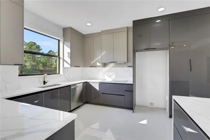 Kitchen featuring gray cabinets, modern cabinets, light stone counters, and recessed lighting