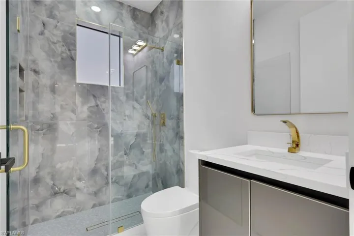 Full bathroom with vanity and a marble finish shower