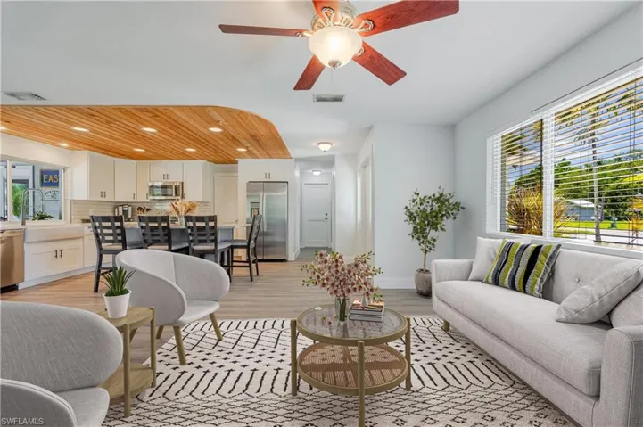 Living room with sink, ceiling fan, and light hardwood / wood-style flooring