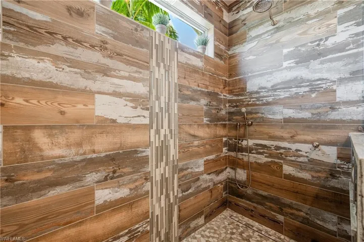 Interior details featuring a shower and wood walls