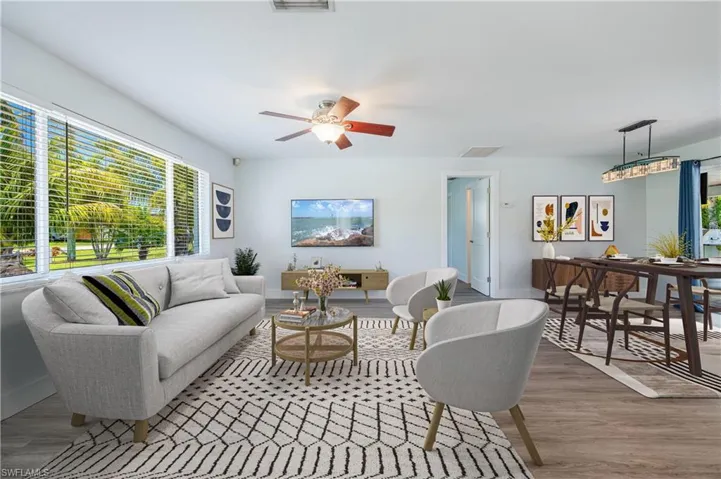 Living room with ceiling fan and hardwood / wood-style flooring
