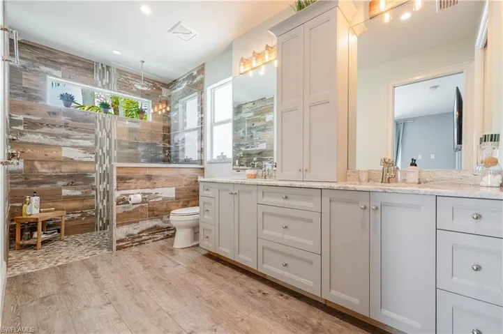 Bathroom with hardwood / wood-style floors, oversized vanity, and toilet