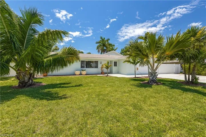 Single story home with a front yard and a garage