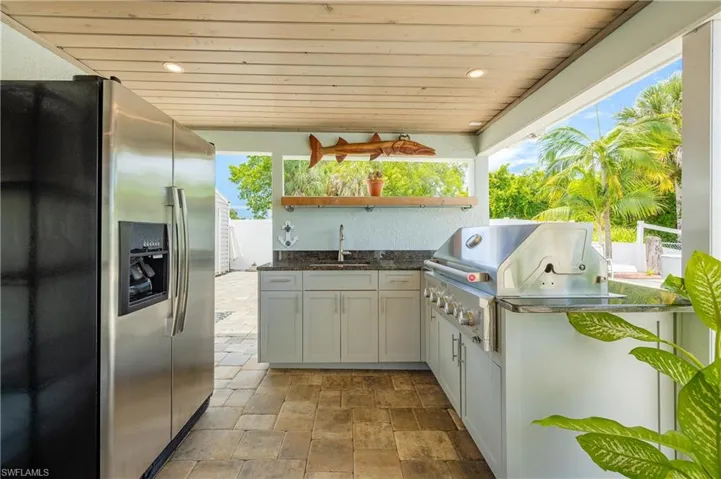 View of patio with ceiling fan, sink, grilling area, and area for grilling