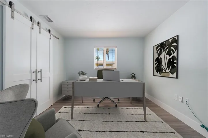 Home office featuring a barn door and wood-type flooring