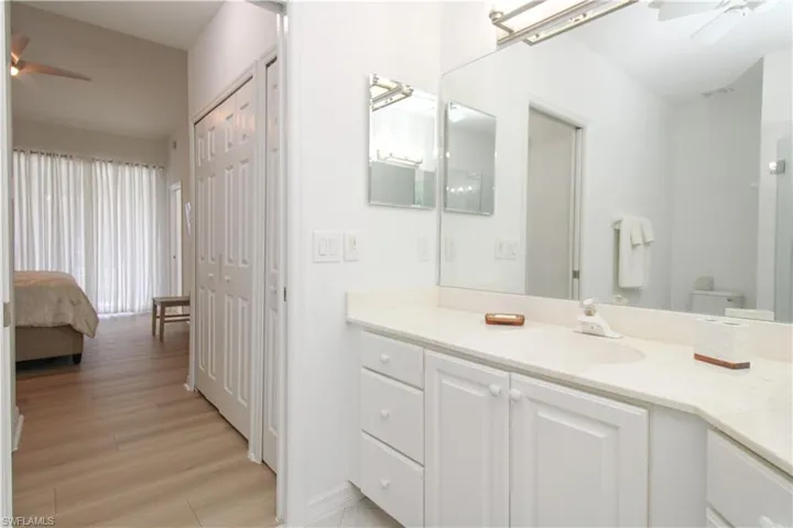 Bathroom with ceiling fan, toilet, vanity, and hardwood / wood-style flooring