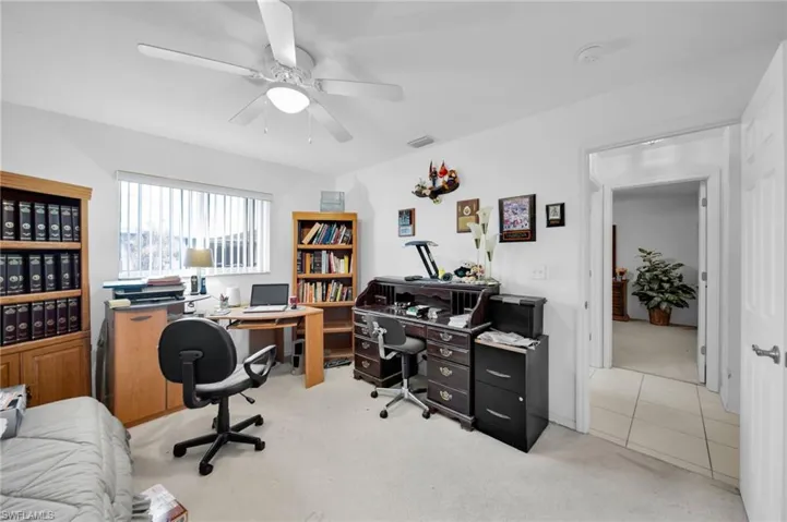 Office area featuring light colored carpet and ceiling fan