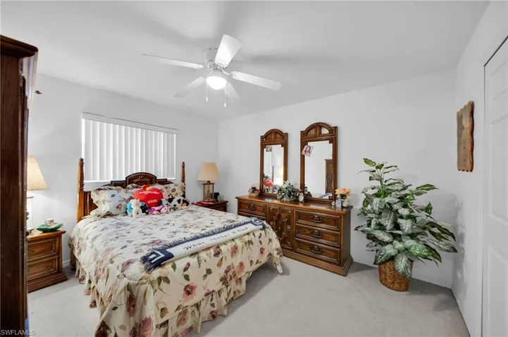 Bedroom with light carpet and a ceiling fan