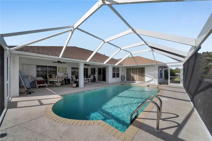 Swimming pool featuring a sunroom, a patio area, and glass enclosure