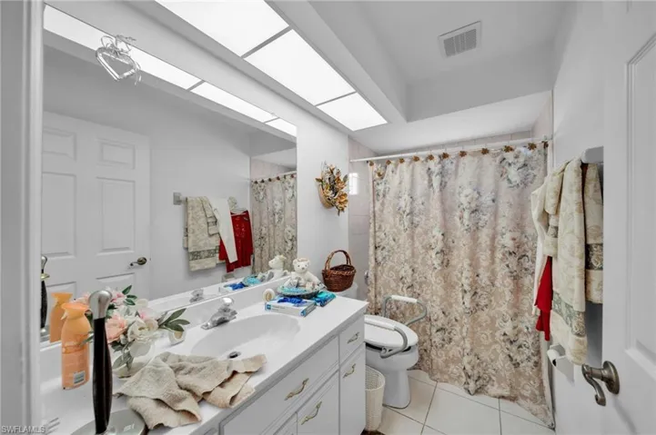 Full bath featuring vanity and light tile patterned flooring