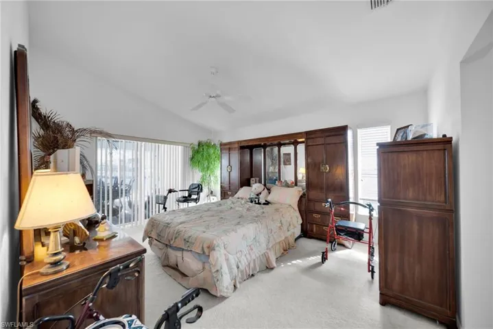 Bedroom with light carpet, lofted ceiling, and ceiling fan