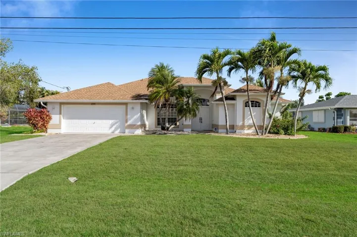 Ranch-style house featuring a garage, driveway, a front yard, stucco siding, and a shingled roof
