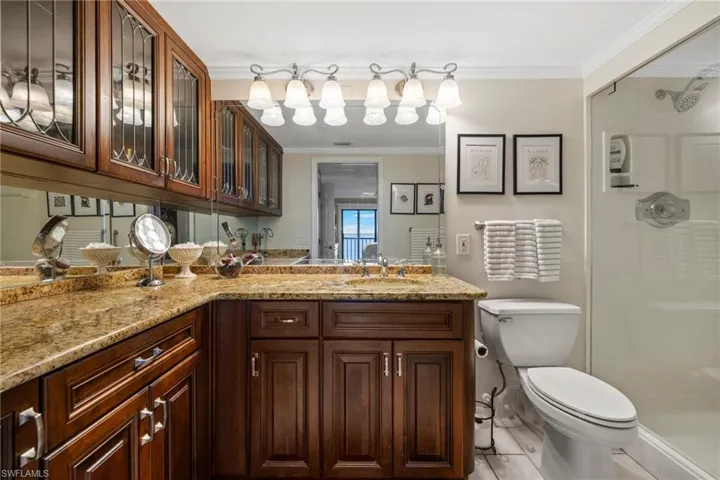 Bathroom with wood cabinets, granite and glass partition shower