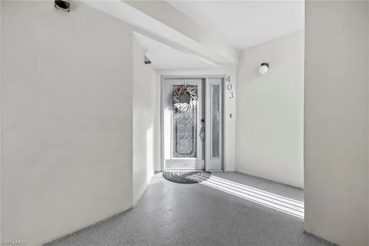 Front door to home in a covered, screened hallway off the elevator.