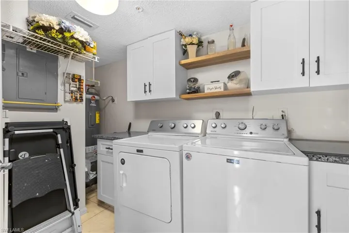 Laundry room & utility area with cabinets for storage and decorative shelves