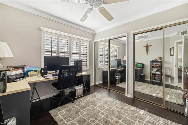 Guest bedroom with new hard wood floors used as office.  Mirrored closet doors with closet system.