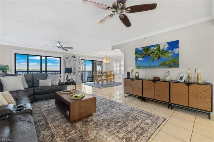 Tiled living room with crown & base molding that leads into the formal dining room.