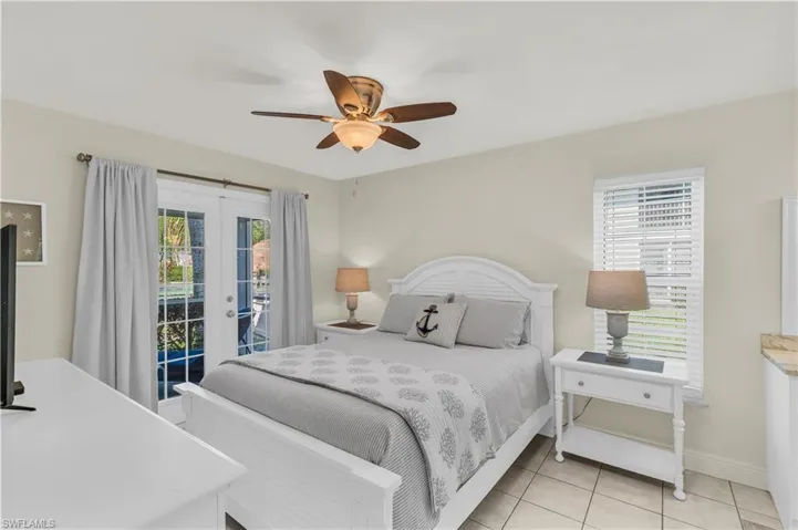 furnished Primary Bedroom with baseboards, ceiling fan, access to outside, french doors, and light tile patterned floors