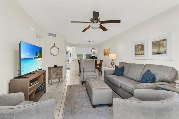 Living area with light tile patterned flooring, and a ceiling fan