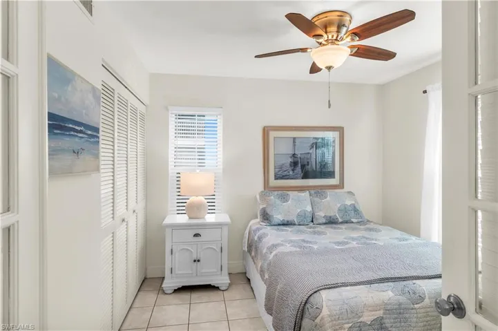 Guest Bedroom ceiling fan, and light tile patterned floors