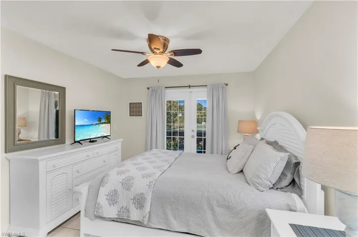 Bedroom with a ceiling fan and access to outside through french doors.